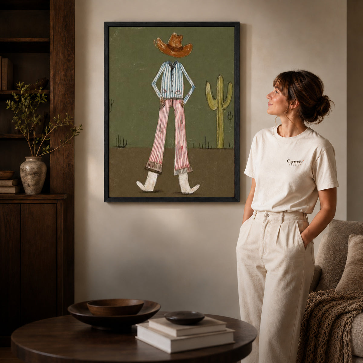Black framed cowboy canvas wall art displayed beside a woman with natural light across the wall.