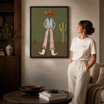 Black framed cowboy canvas wall art displayed beside a woman with natural light across the wall.