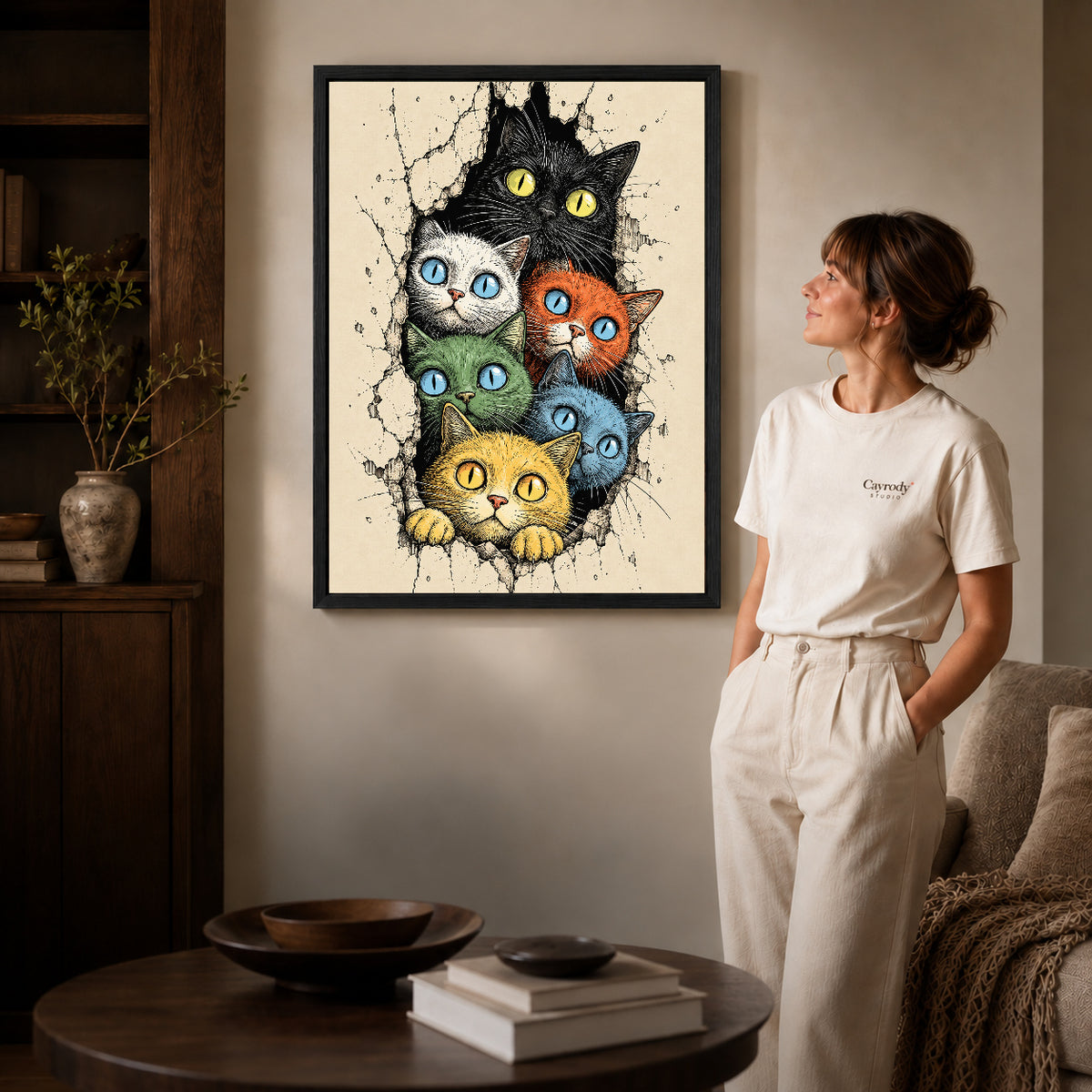Colorful Cat Canvas Art inside a black frame in a softly lit living room with books.