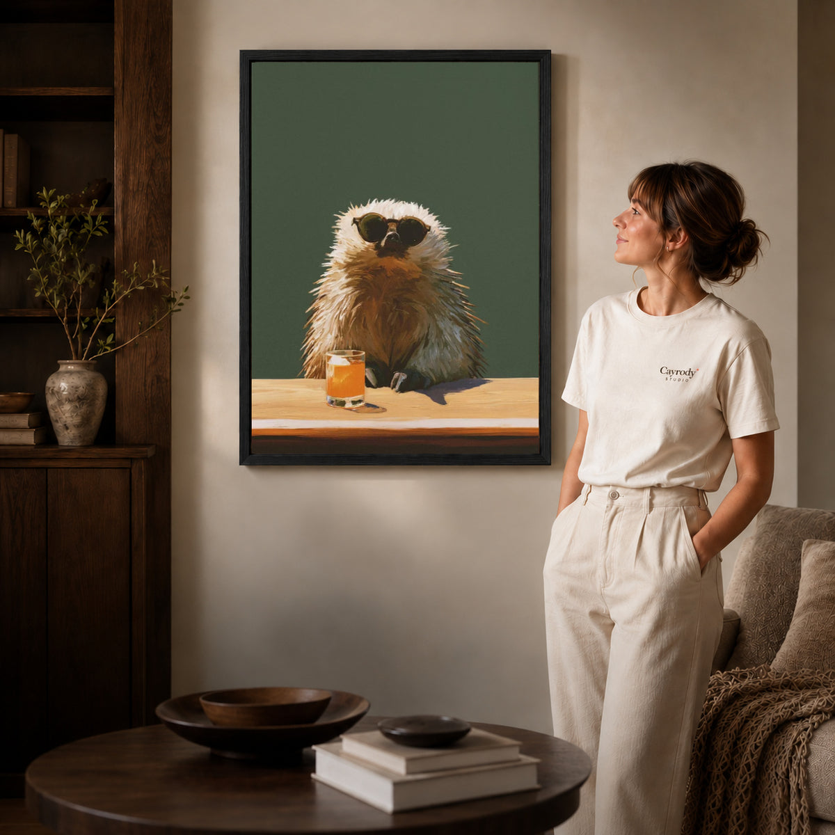 Black framed capybara canvas wall art displayed beside a woman with natural light across the wall.