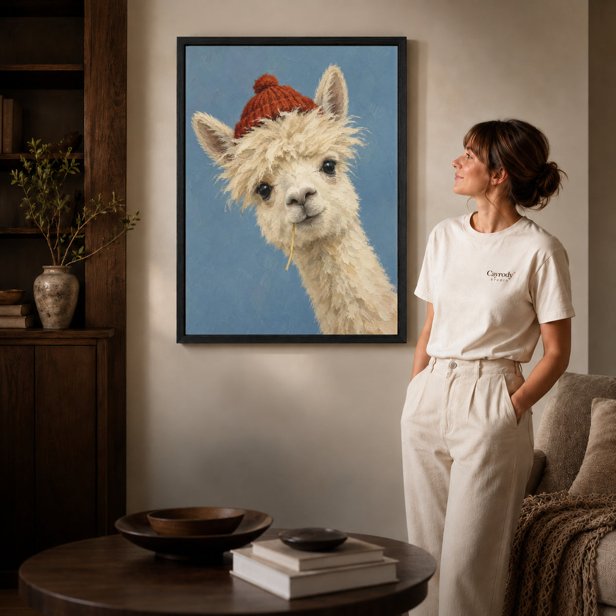 Black framed llama canvas wall art displayed beside a woman with natural light across the wall.