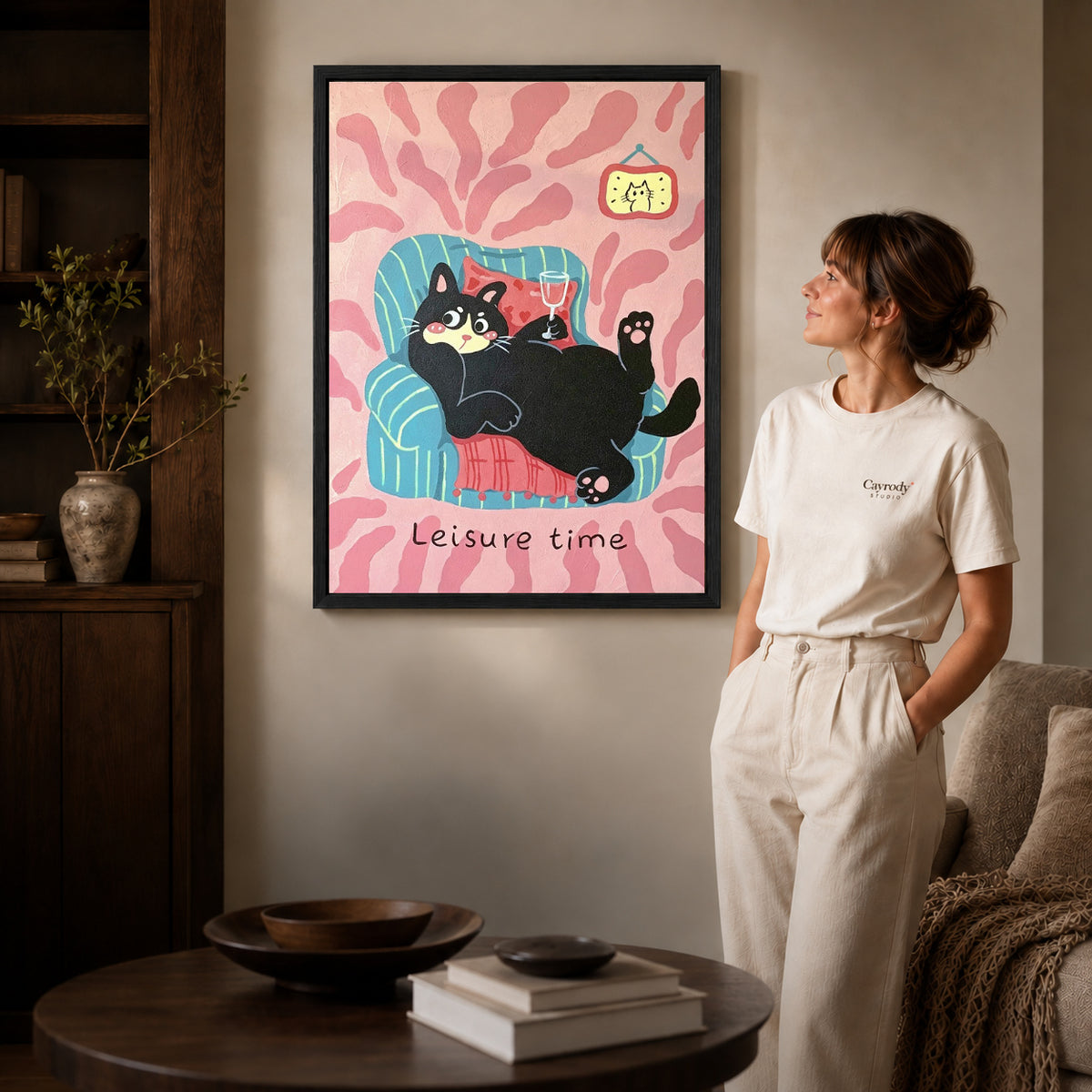 Relaxing Cat Canvas Art inside a black frame in a softly lit living room with books.