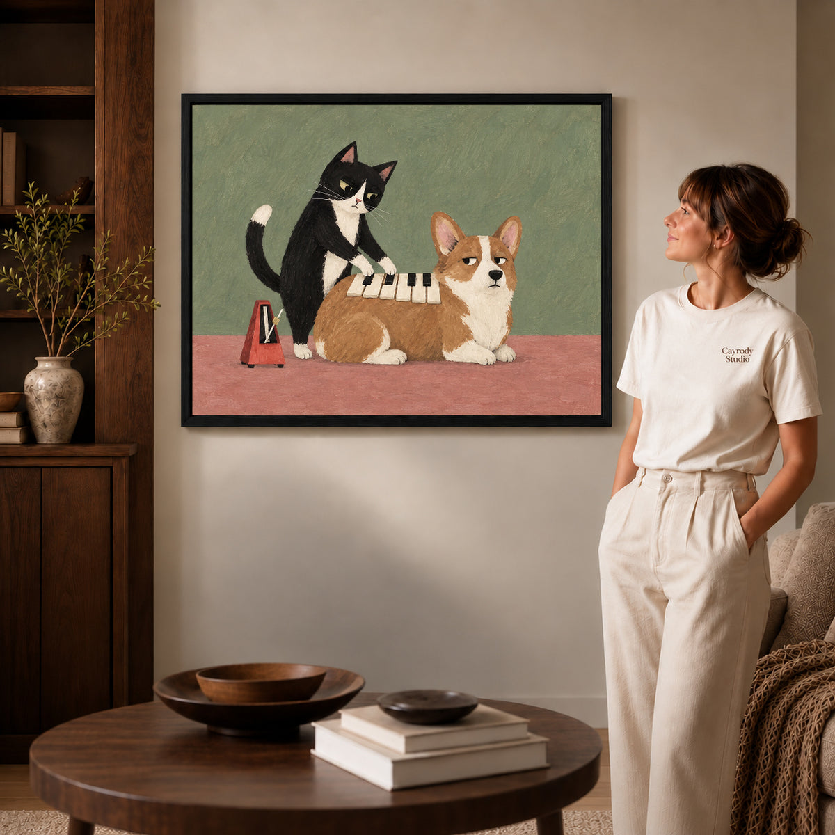 Black framed musical pet canvas art displayed beside a woman with natural light across the wall.