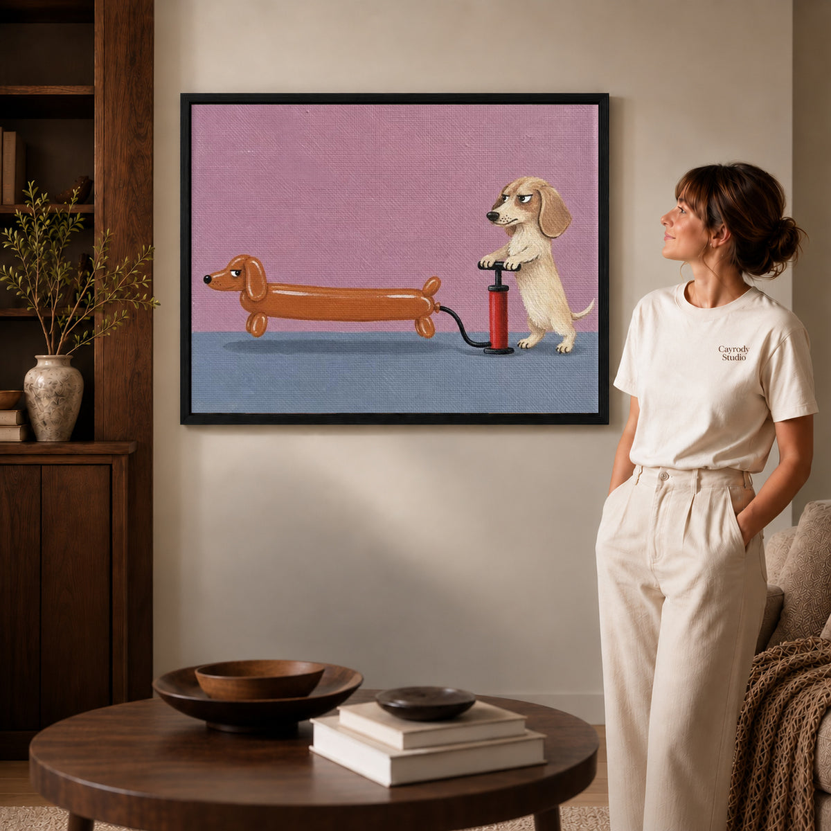 Black framed funny dog canvas art displayed beside a woman with natural light across the wall.