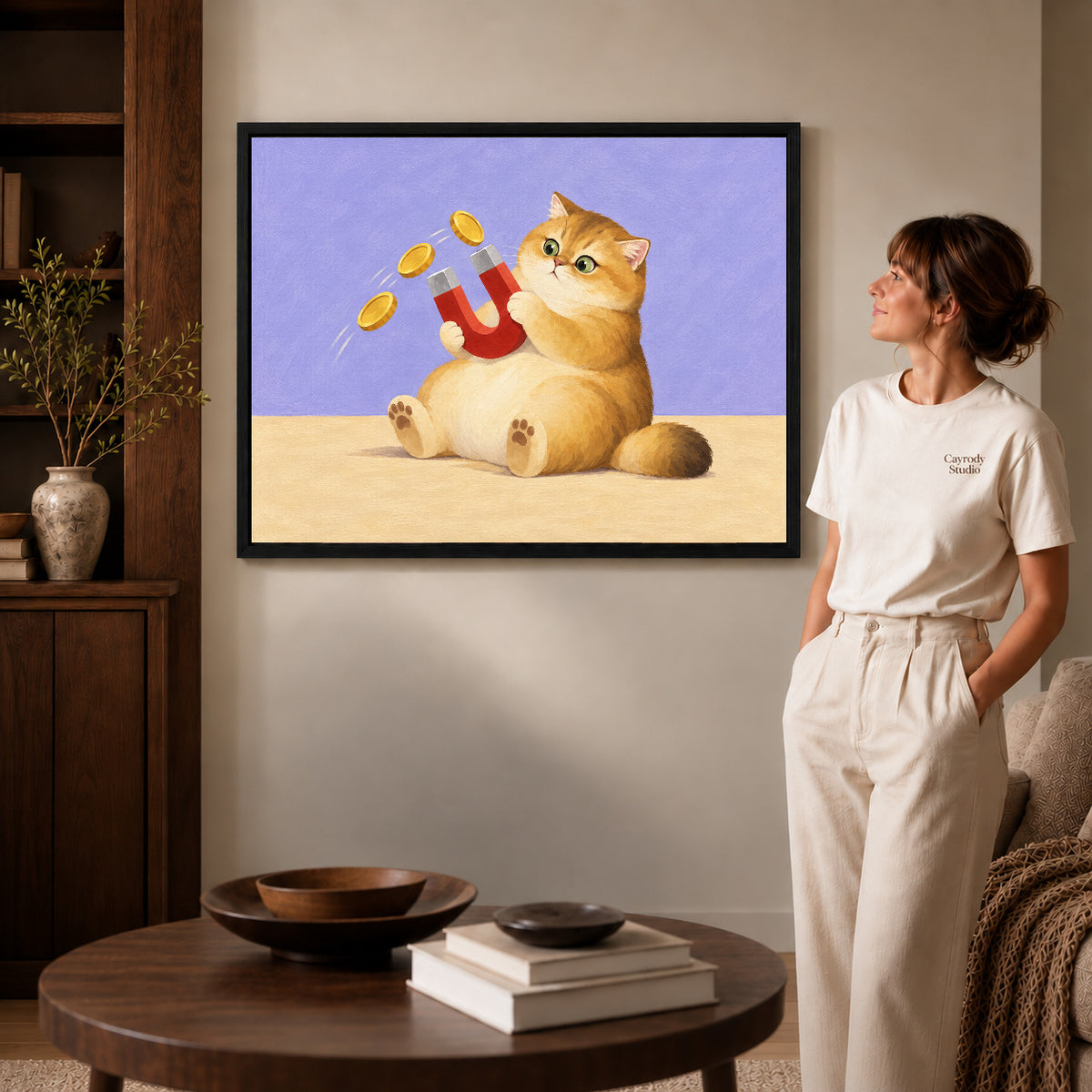 Black framed golden cat canvas art displayed beside a woman with natural light across the wall.