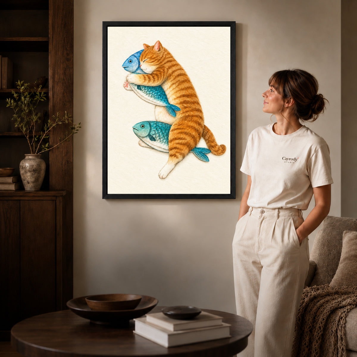 Orange Cat Canvas Art inside a black frame in a softly lit living room with books.