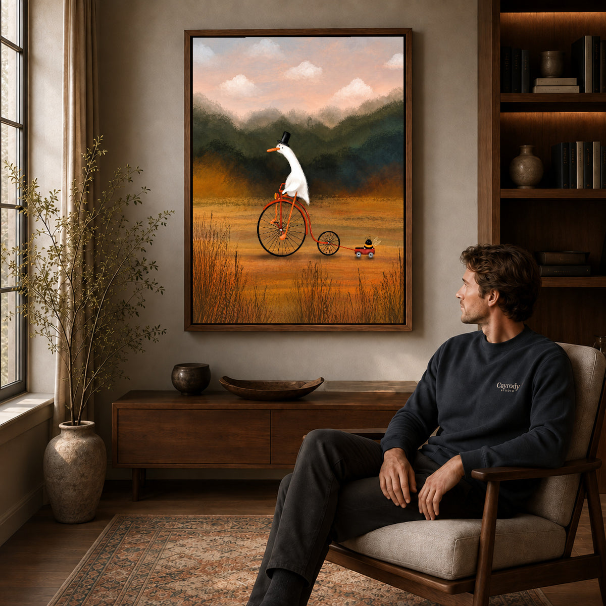 Goose Canvas Wall Art displayed in a walnut frame above wooden furniture beside a seated man.