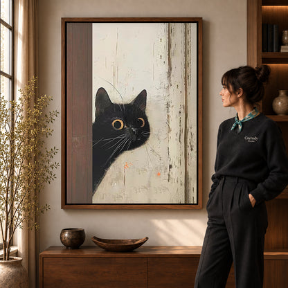 Black Cat Canvas Art in a walnut frame beside a standing woman and warm wooden furniture.