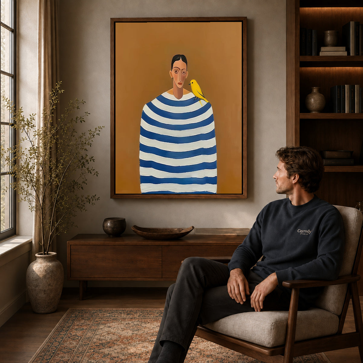 Canary Canvas Wall Art displayed in a walnut frame above wooden furniture beside a seated man.
