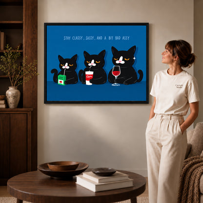 Black framed sassy cat trio canvas art displayed beside a woman with natural light across the wall.