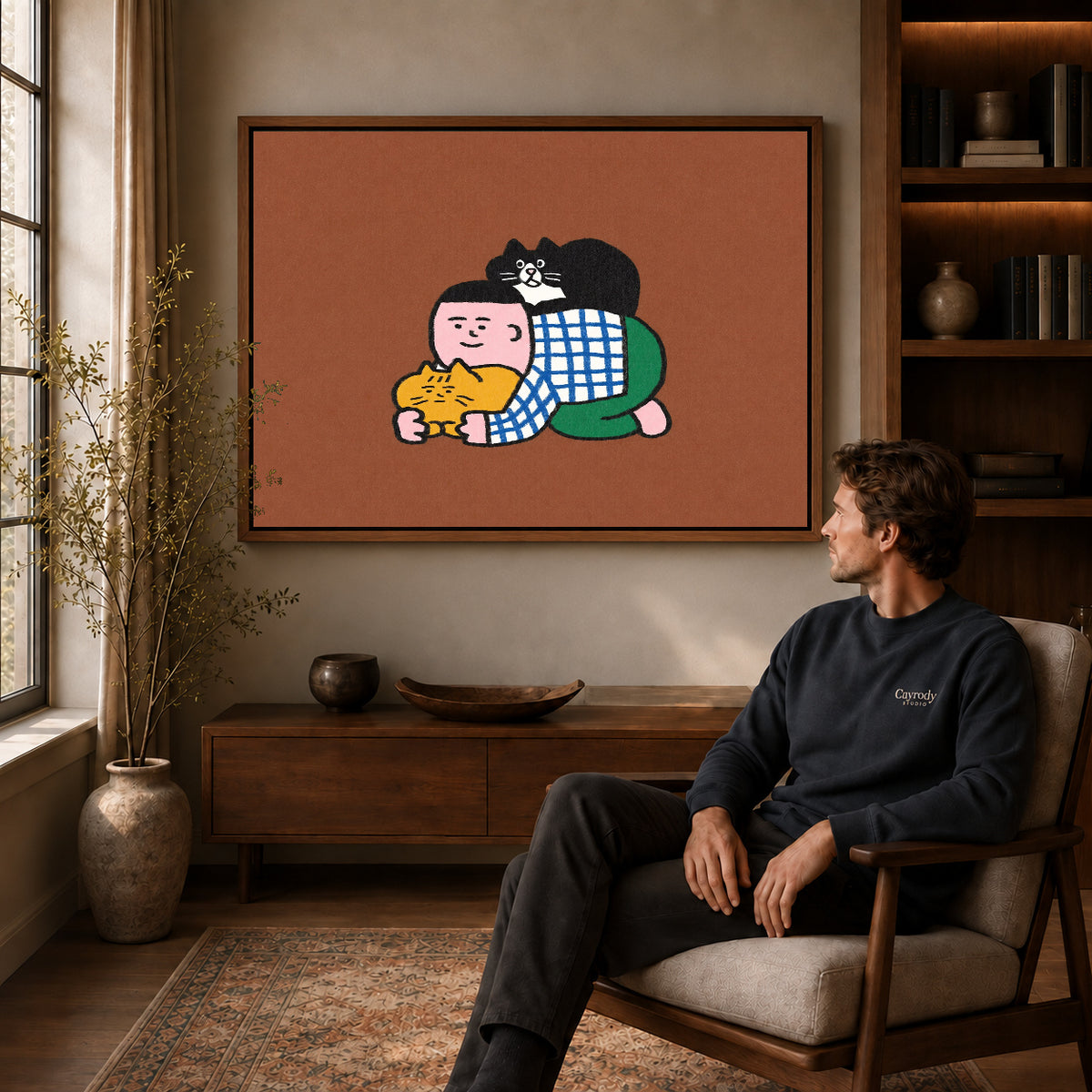 Cuddling Cats Canvas Art displayed in a walnut frame above wooden furniture beside a seated man.
