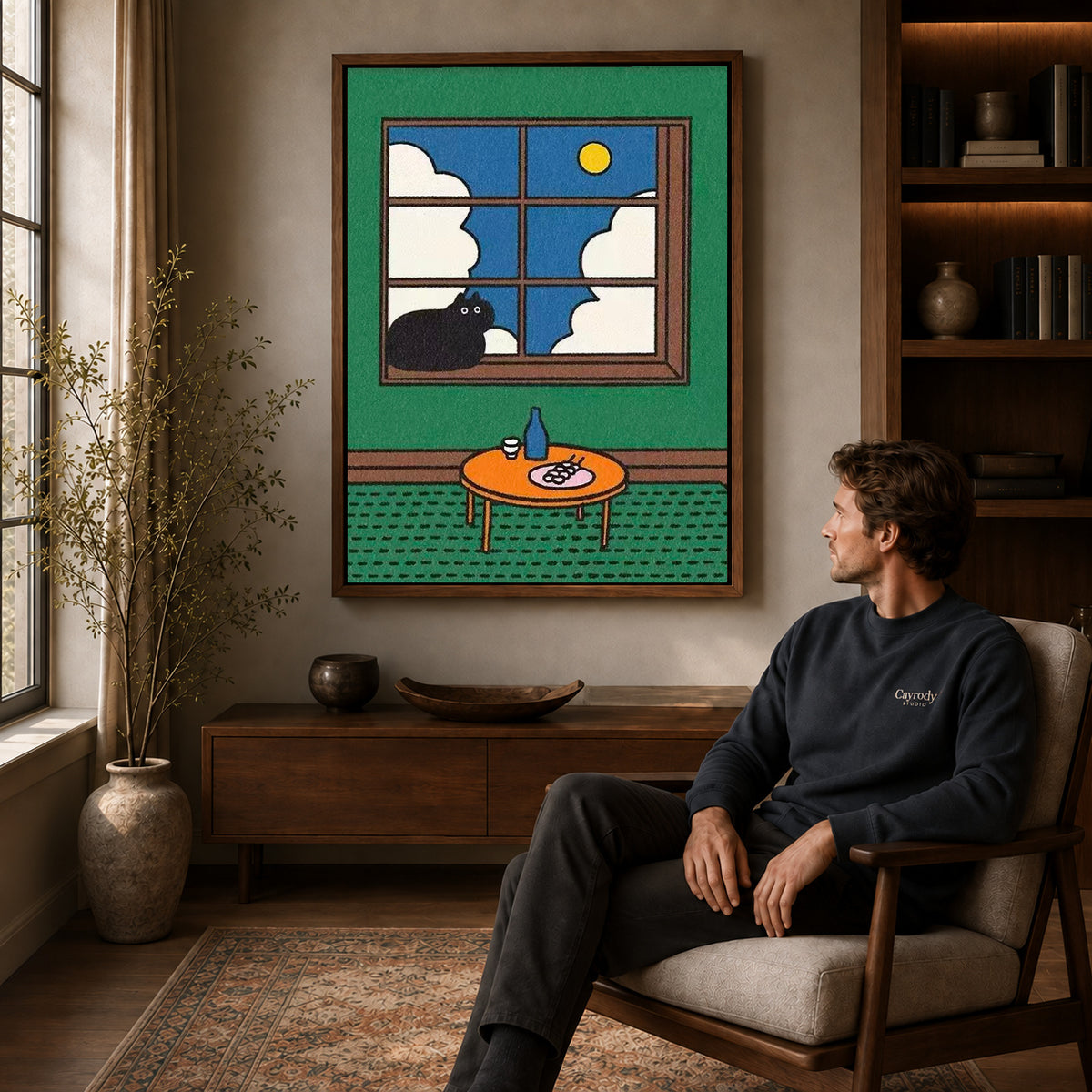 Window Cat Canvas Art displayed in a walnut frame above wooden furniture beside a seated man.