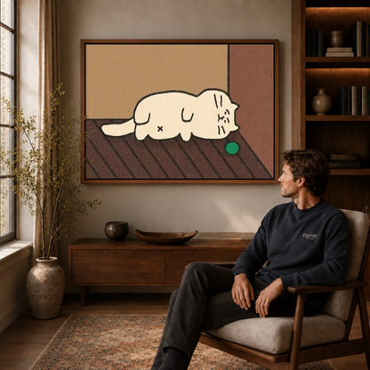 Sleepy Cat Canvas Art displayed in a walnut frame above wooden furniture beside a seated man.