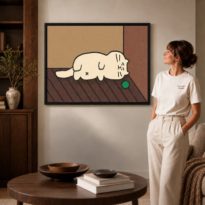 Black framed sleepy cat canvas art displayed beside a woman with natural light across the wall.