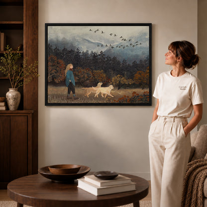 Autumn Dog Walk Canvas Art inside a black frame in a softly lit living room with books.
