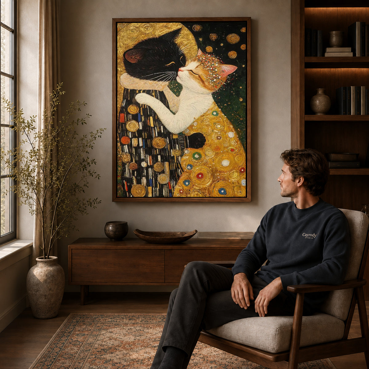 Golden Cat Embrace Canvas Art displayed in a walnut frame above wooden furniture beside a seated man.