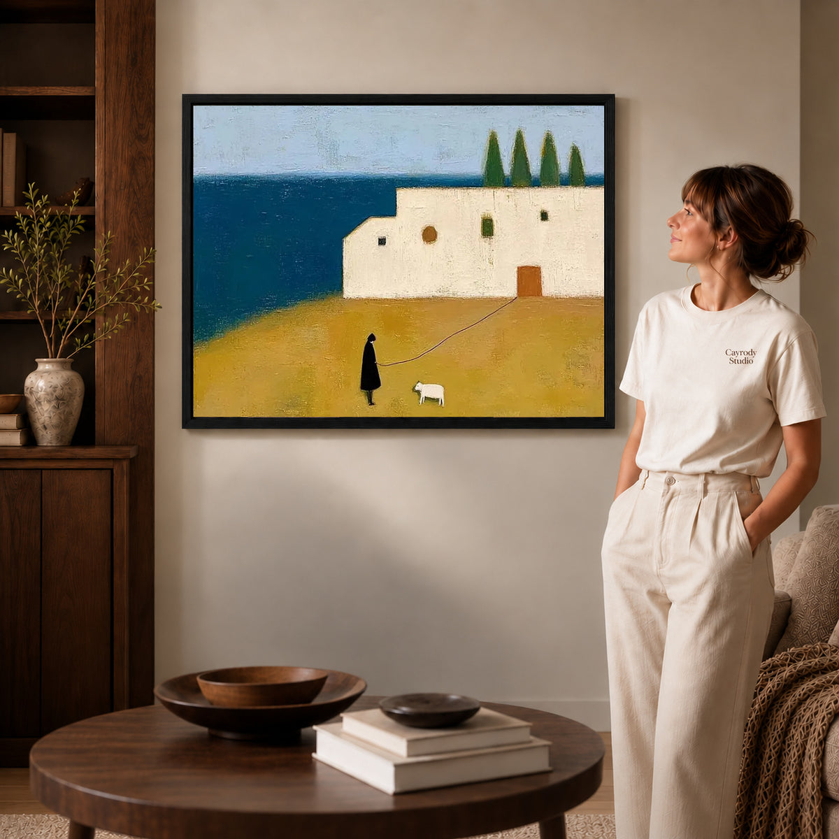 Coastal Companion Canvas Art inside a black frame in a softly lit living room with books.