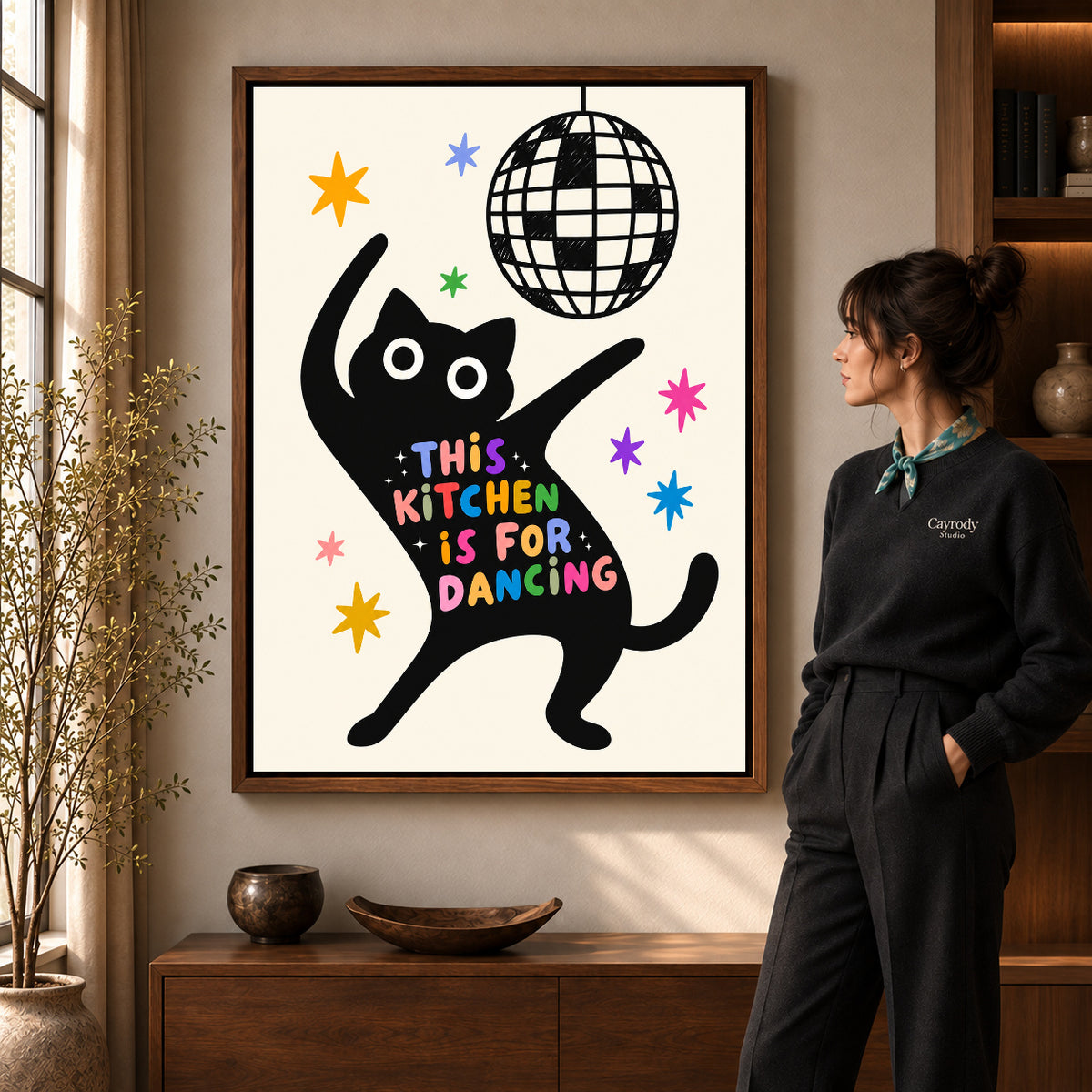 dancing kitchen cat canvas art shown in the walnut frame option within a warm living room.