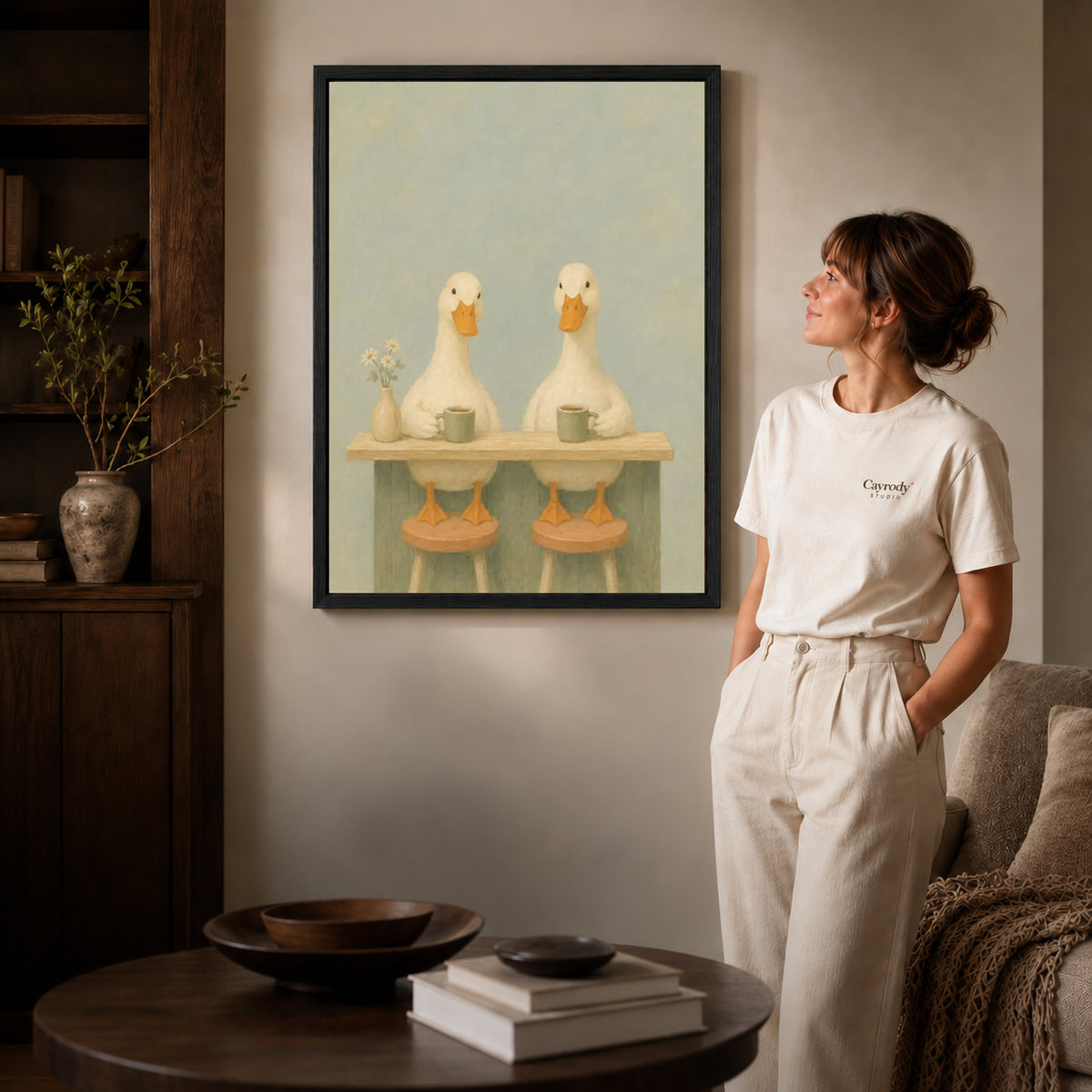 Coffee Duck Canvas Art inside a black frame in a softly lit living room with books.