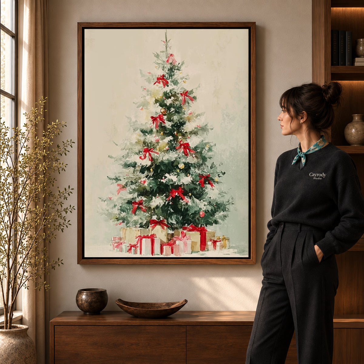 Snowy Christmas Tree Canvas Art in a walnut frame beside a standing woman and warm wooden furniture.