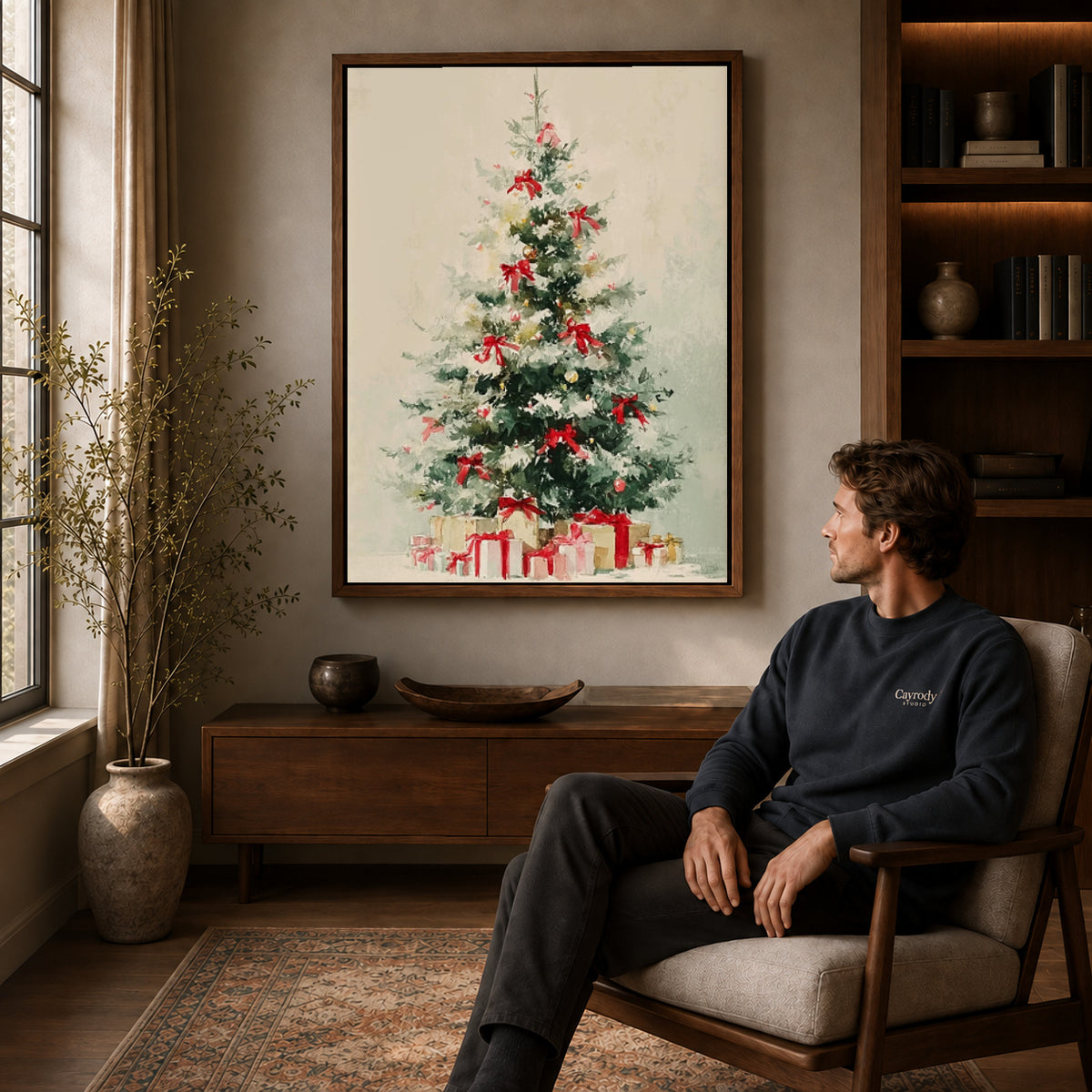 Snowy Christmas Tree Canvas Art displayed in a walnut frame above wooden furniture beside a seated man.