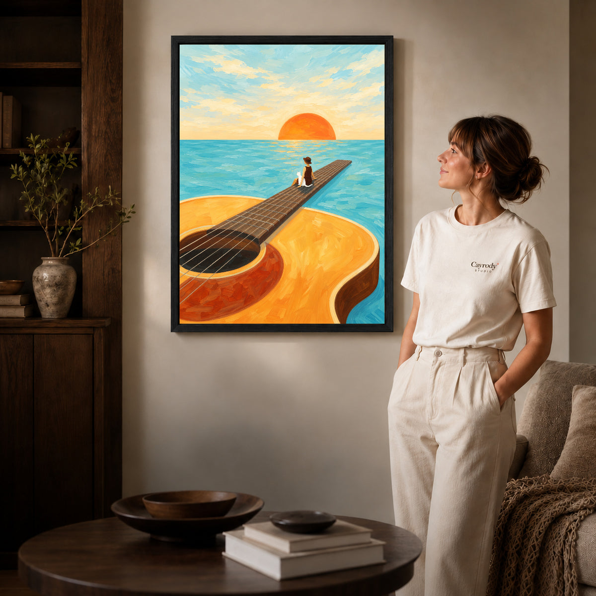 Black framed surreal guitar canvas art displayed beside a woman in a warm wood living room.