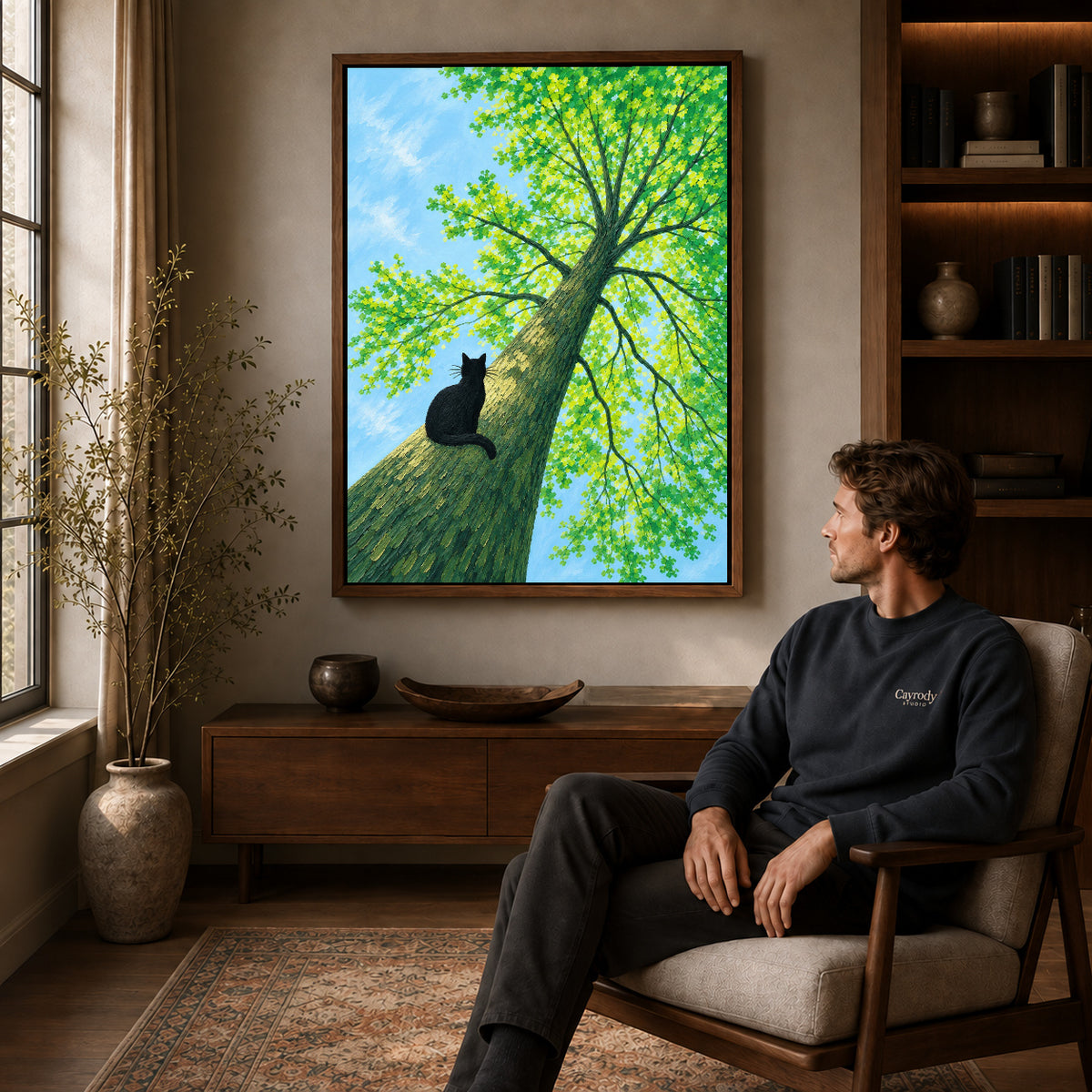 Walnut framed black cat tree canvas art above a seated man in a cozy wood furnished living room.