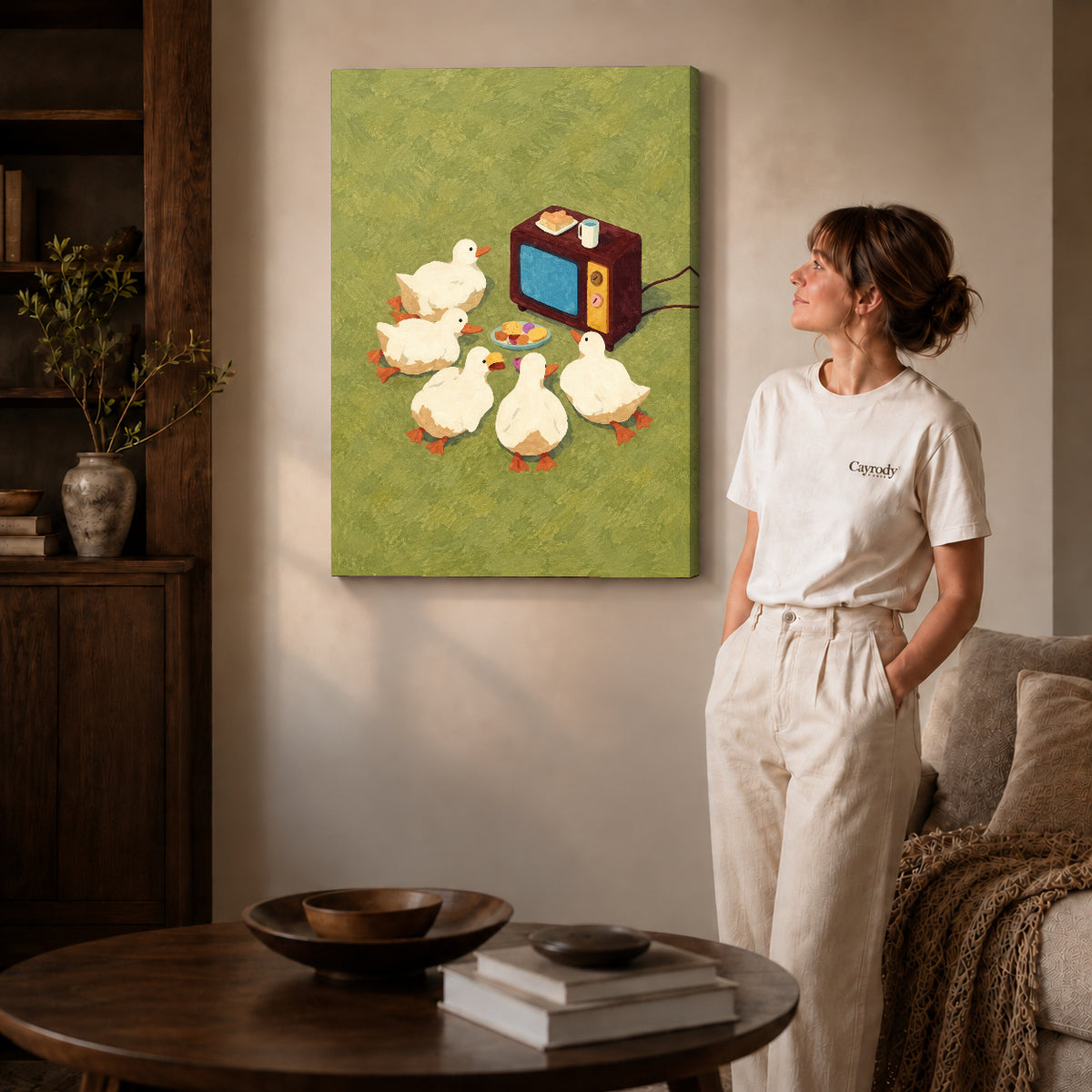 Gallery wrapped funny duck television canvas art with subtly shaded canvas edges beside a woman wearing cream clothing.