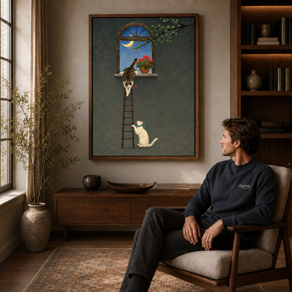 Walnut framed moonlit ladder cats canvas art above a seated man in a cozy wood furnished living room.