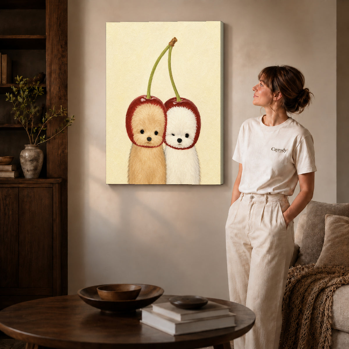 Gallery wrapped cherry puppy canvas art with subtly shaded canvas edges beside a woman wearing cream clothing.