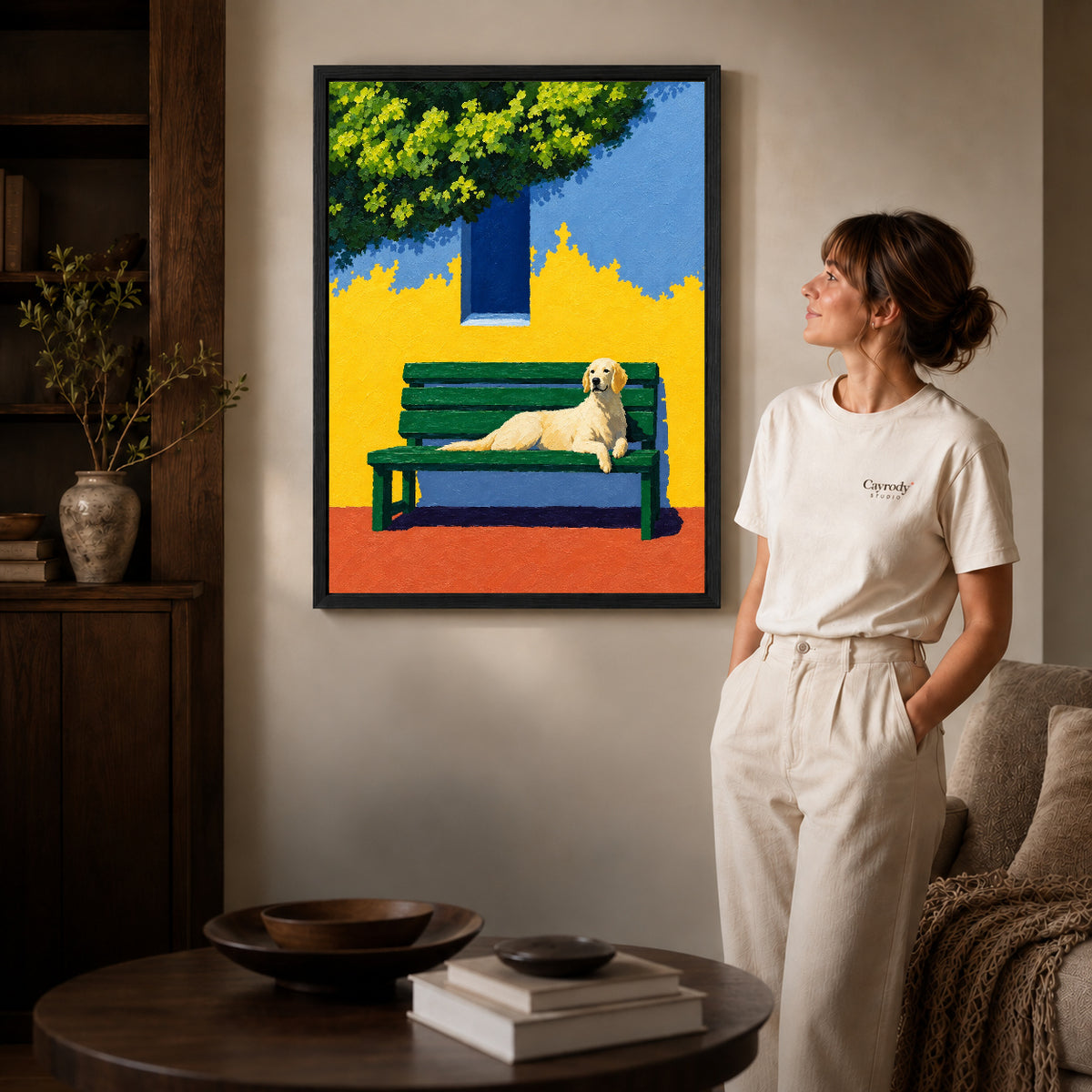 Black framed golden retriever bench canvas art displayed beside a woman in a warm wood living room.