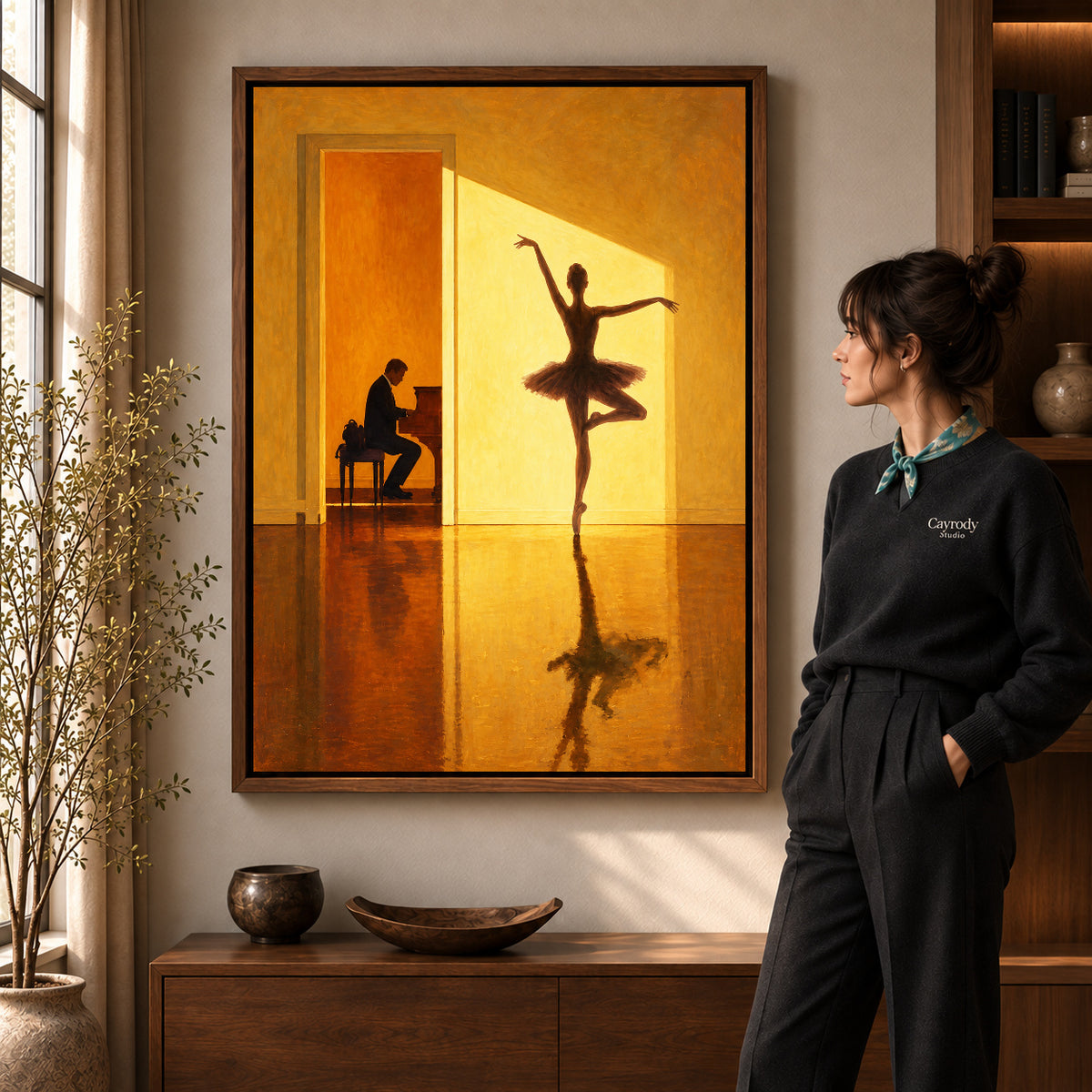 Golden ballerina canvas art in a walnut frame beside a woman in a warm living room.