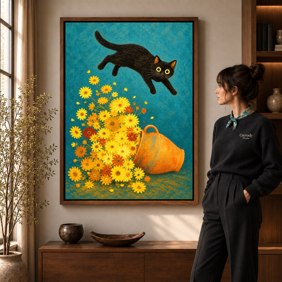 Playful cat daisy canvas art in a walnut frame beside a woman in a warm living room.