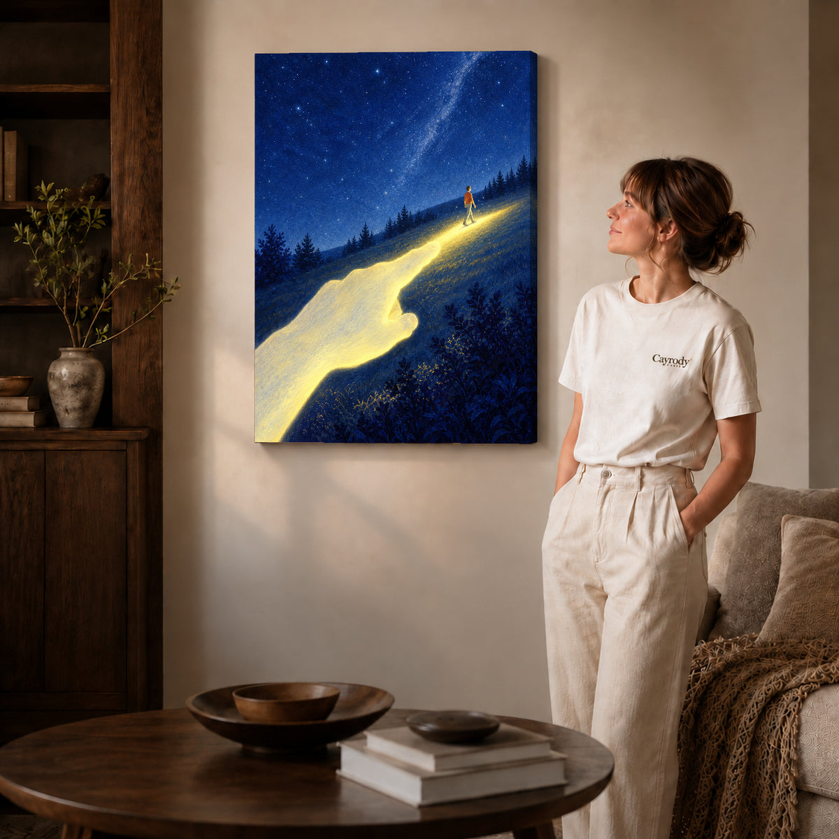 Gallery wrapped guiding light canvas art with subtly shaded canvas edges beside a woman wearing cream clothing.