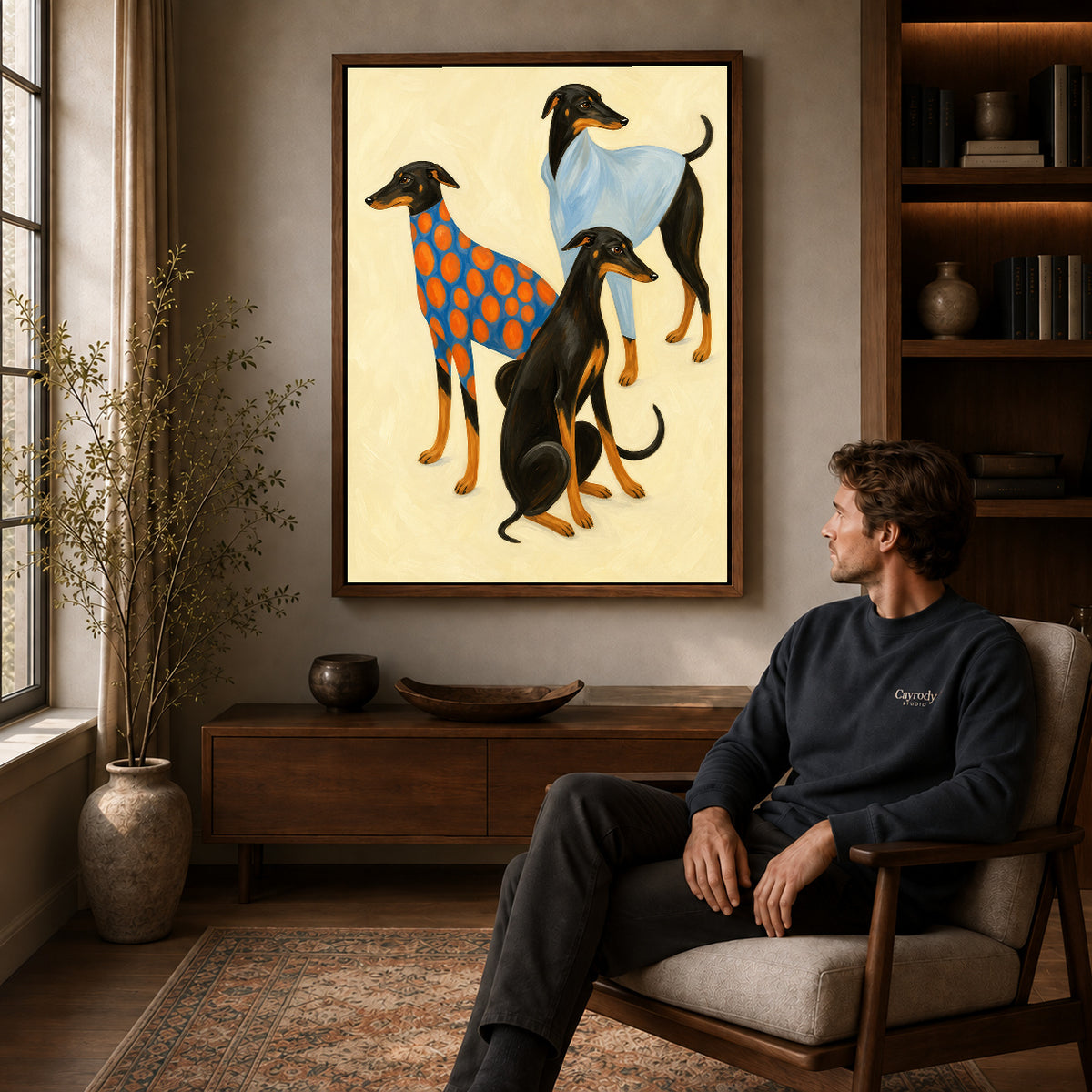 Walnut framed stylish greyhound trio canvas art above a seated man in a cozy wood furnished living room.
