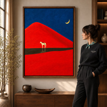Red dune horse canvas art in a walnut frame beside a woman in a warm living room.