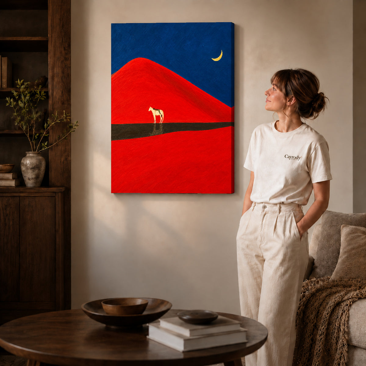 Gallery wrapped red dune horse canvas art with subtly shaded canvas edges beside a woman wearing cream clothing.