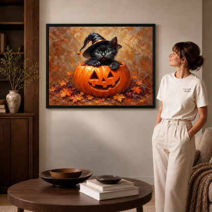 Pumpkin kitten canvas art in a black frame beside a woman and round wooden table.