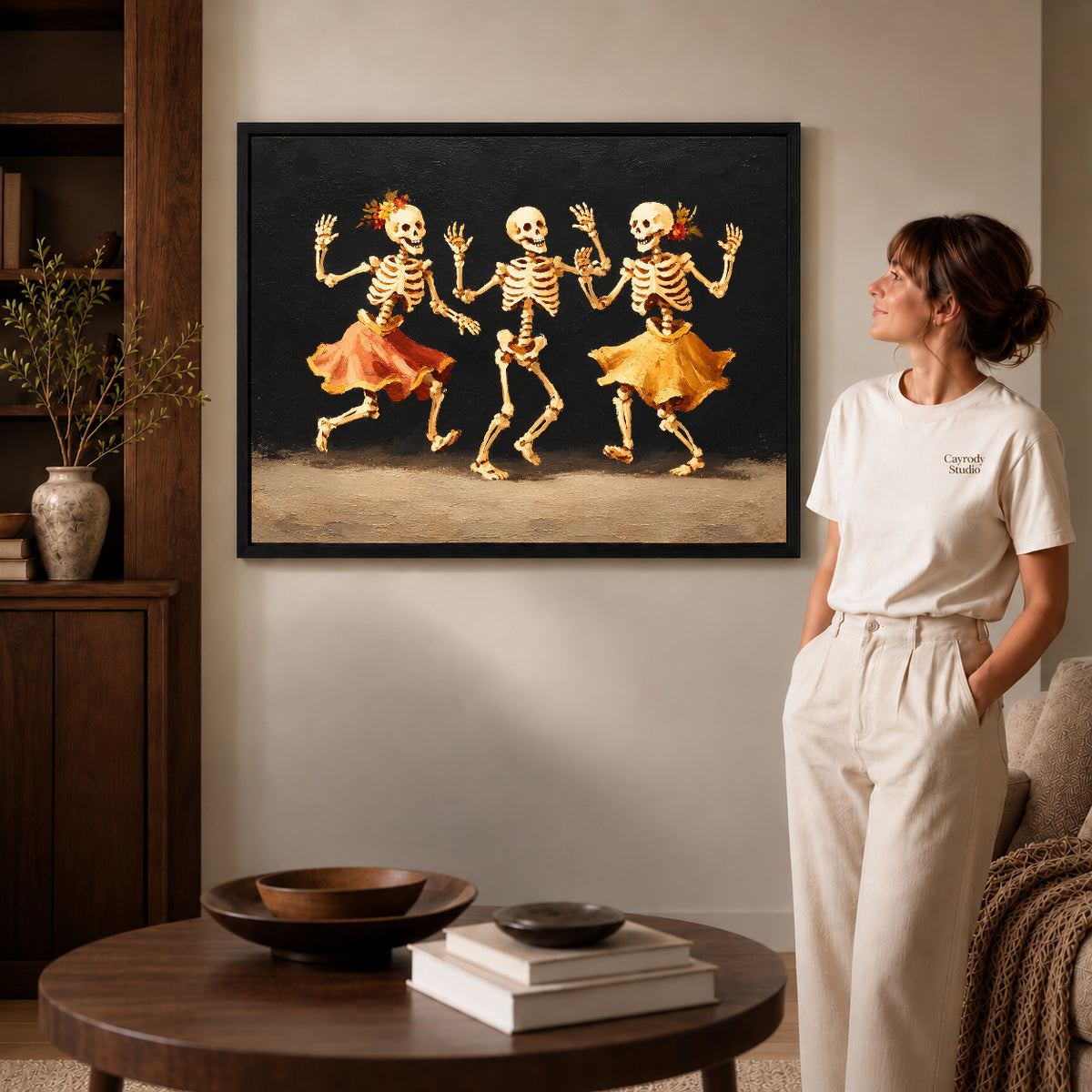 Dancing Skeletons canvas art shown in the black frame option against a softly lit wall.
