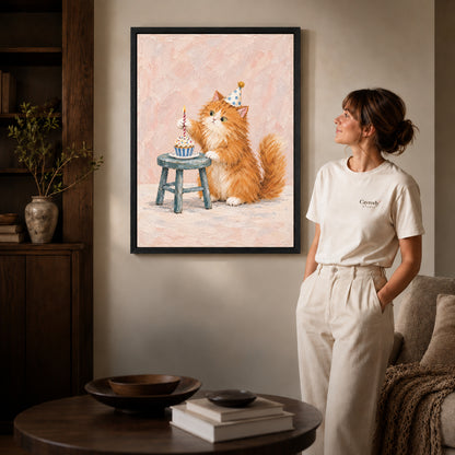 Birthday kitten canvas art in a black frame beside a woman and round wooden table.