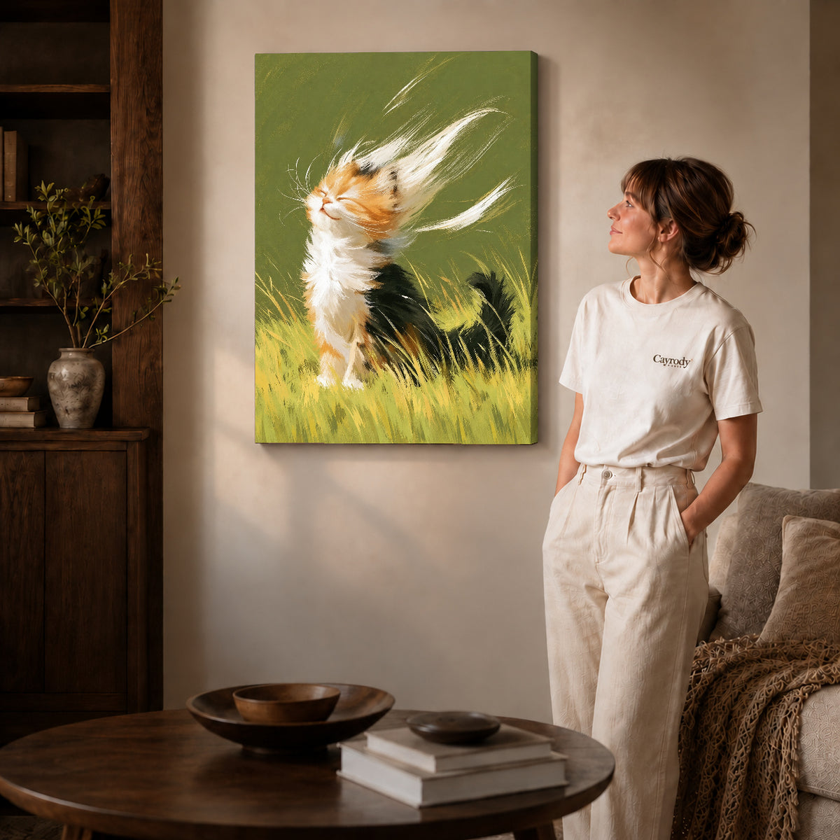 Calico kitten canvas art on gallery-wrapped canvas with natural edge shading beside a standing woman.