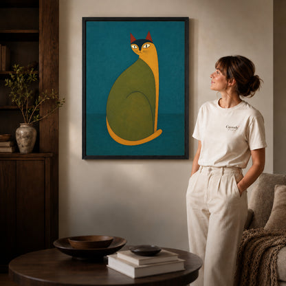 Folk cat canvas art in a black frame beside a woman and round wooden table.