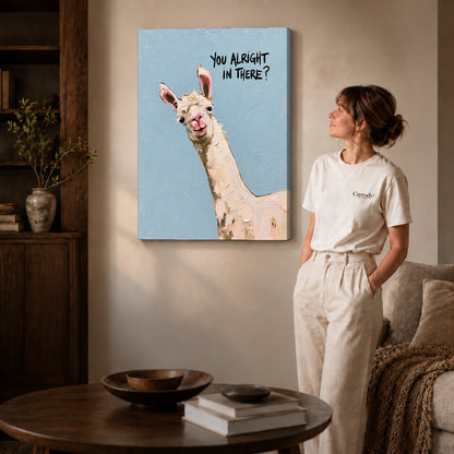 Curious llama canvas art on gallery-wrapped canvas with natural edge shading beside a standing woman.