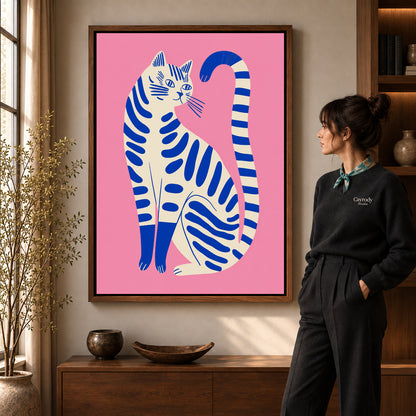 Striped cat canvas art in a walnut frame beside a standing woman and wooden console.