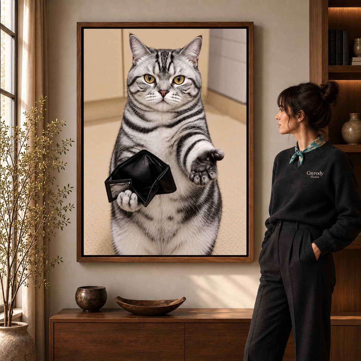 Empty Wallet Cat canvas art in a walnut frame beside a standing woman and wooden console.