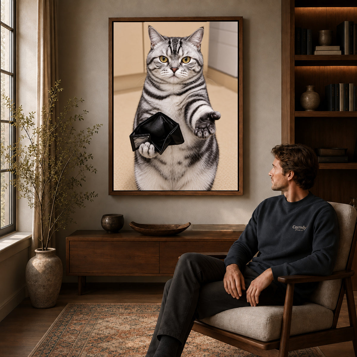 Empty Wallet Cat canvas art in a walnut frame above a console beside a seated man.