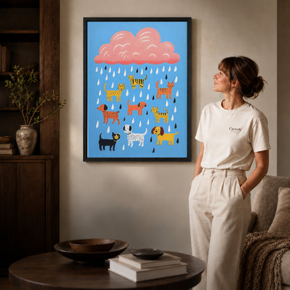 Raining pets canvas art in a black frame beside a woman and round wooden table.