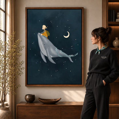 Whale rider canvas art in a walnut frame beside a standing woman and wooden console.