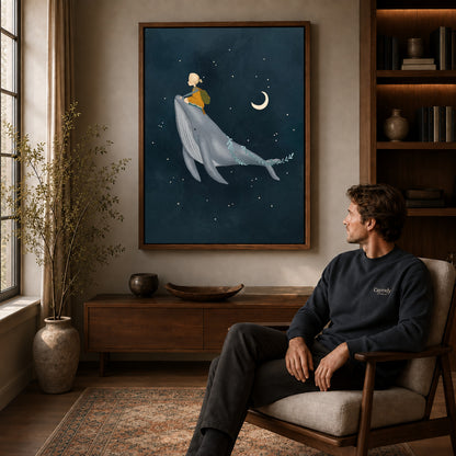 Whale rider canvas art in a walnut frame above a console beside a seated man.