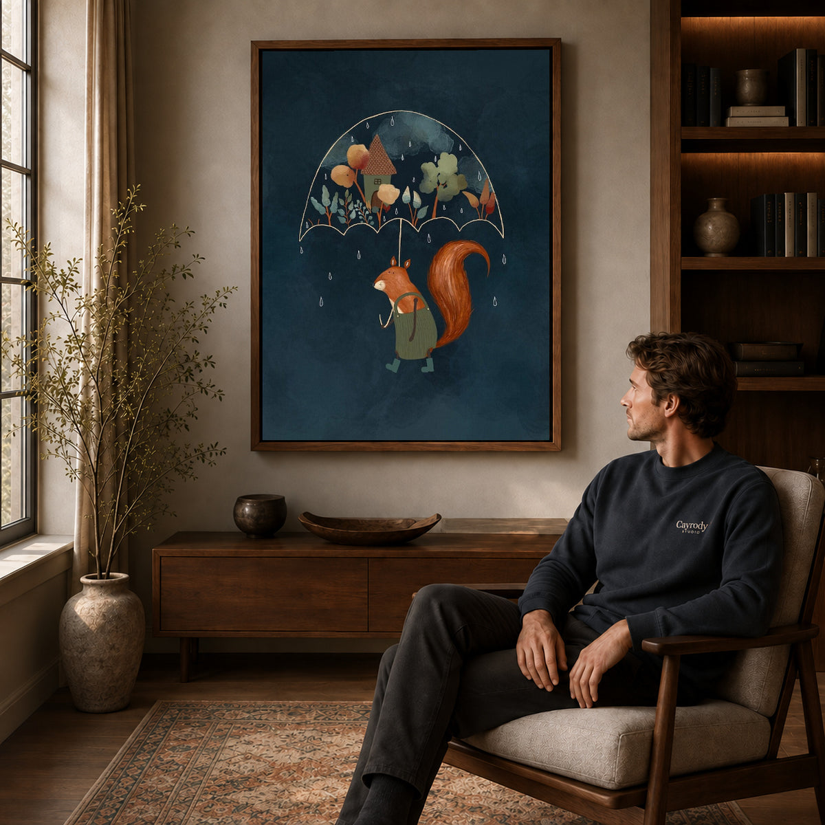 Squirrel umbrella canvas art in a walnut frame above a console beside a seated man.